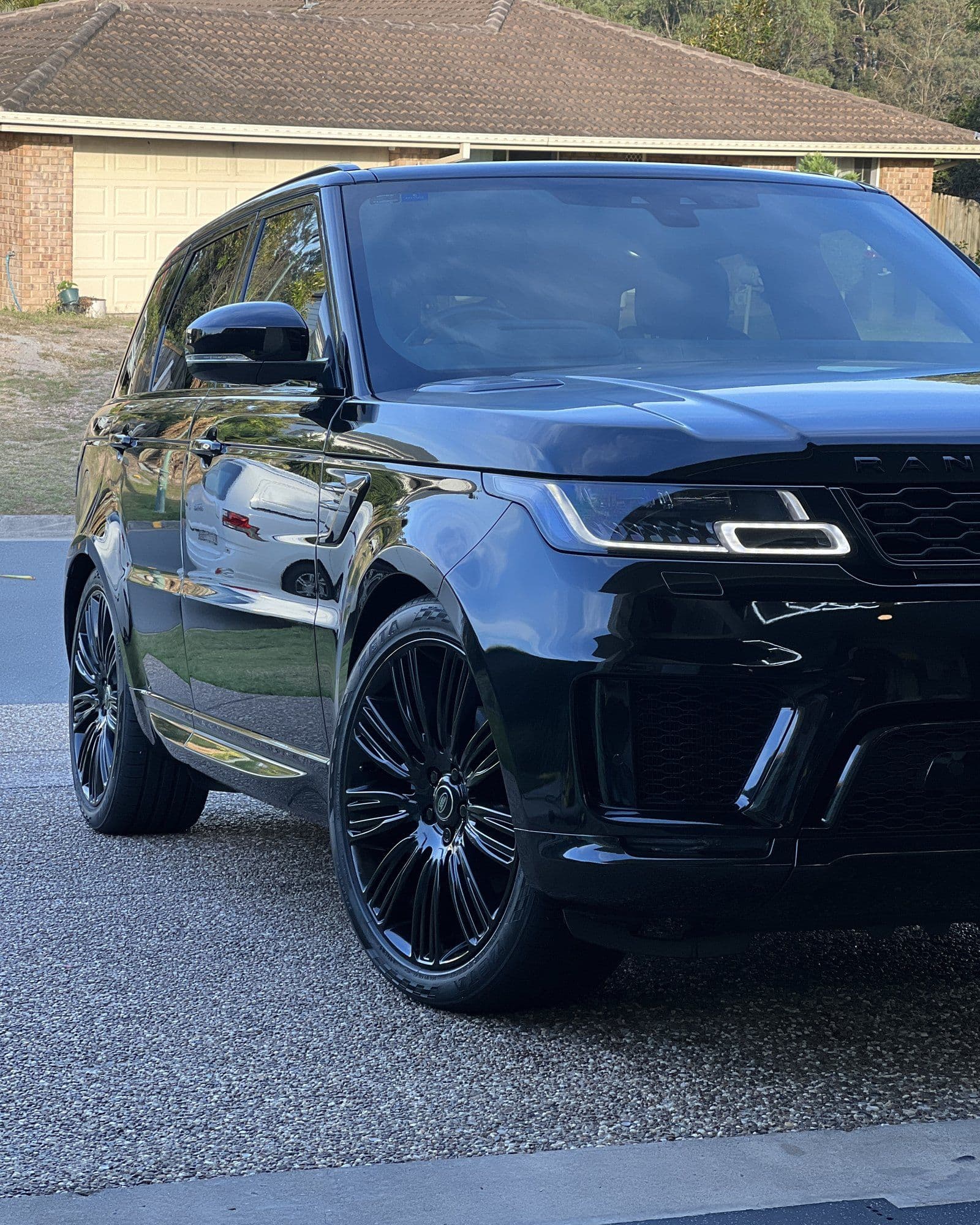 Range Rover Sport finished in gloss black, parked in a driveway