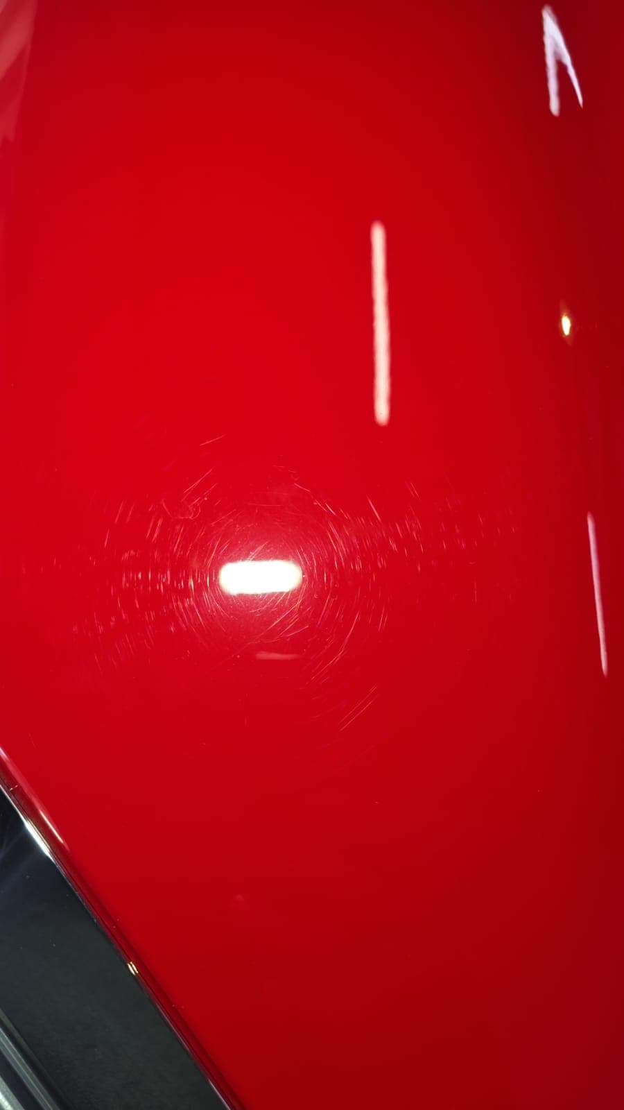 Vehicle panel before paint correction, showing swirl marks and haze