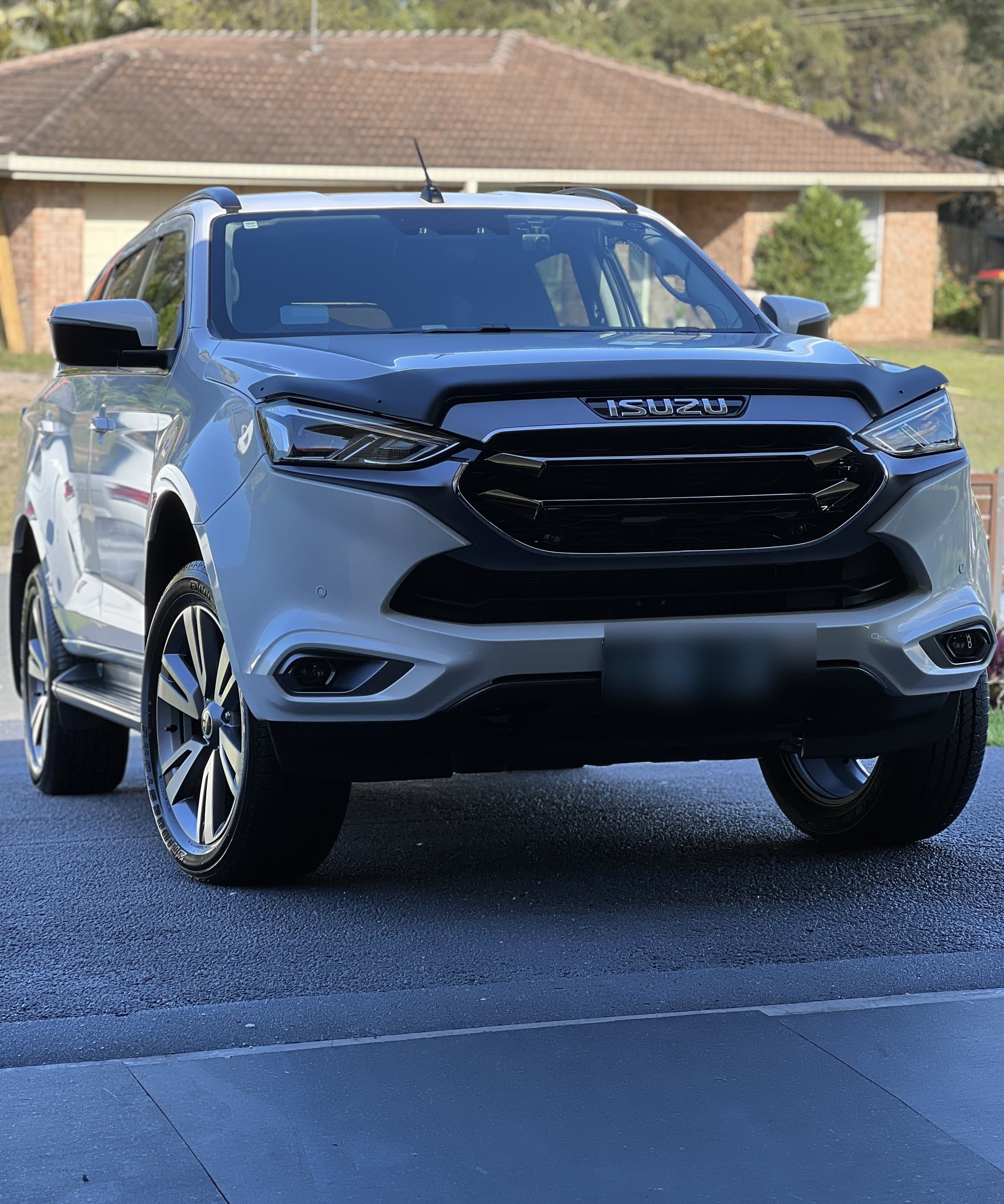 Silver Isuzu SUV parked in a driveway