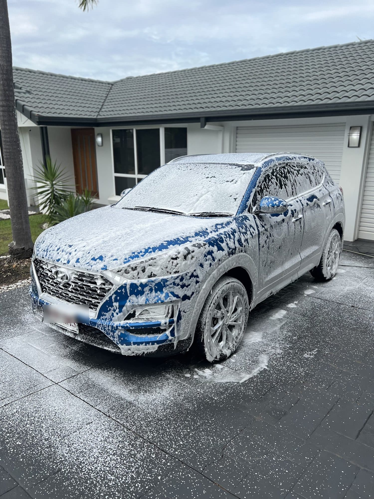 Hyundai Tucson covered in snow foam during a wash